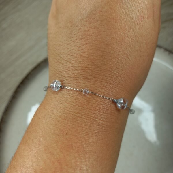 Pulsera fina con bolitas y corazones de cristal.