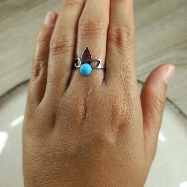Anillo flor calada con perla turquesa.